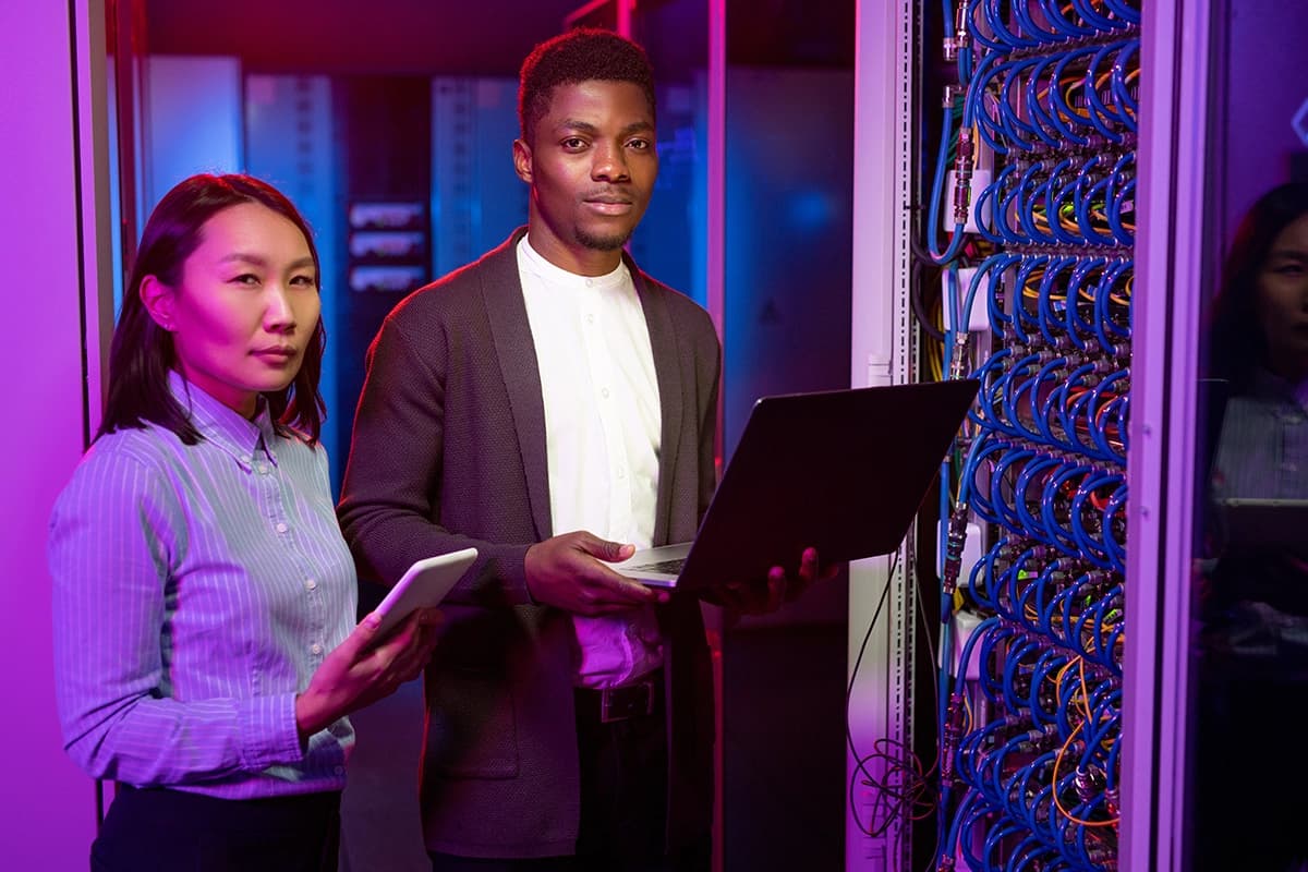 IT engineers with gadgets in server room